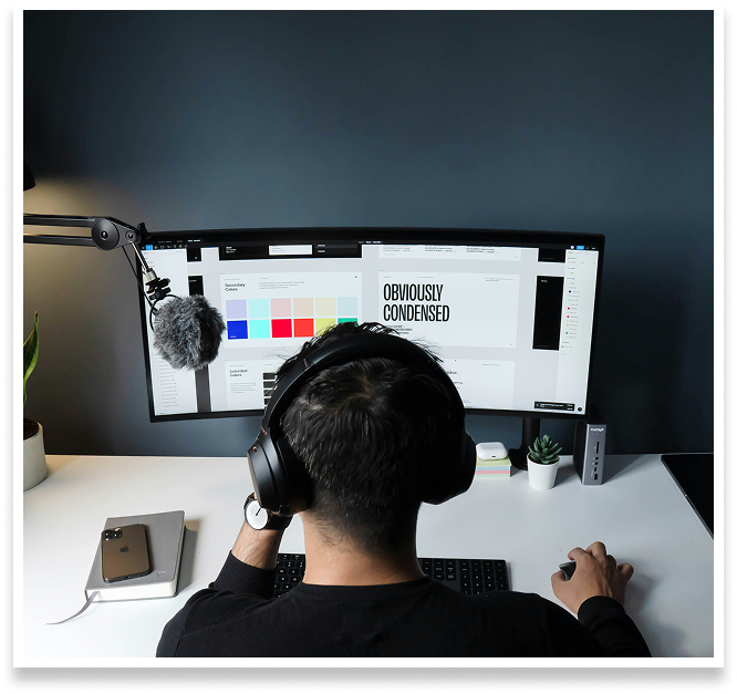 man wearing headphones designing on desktop
